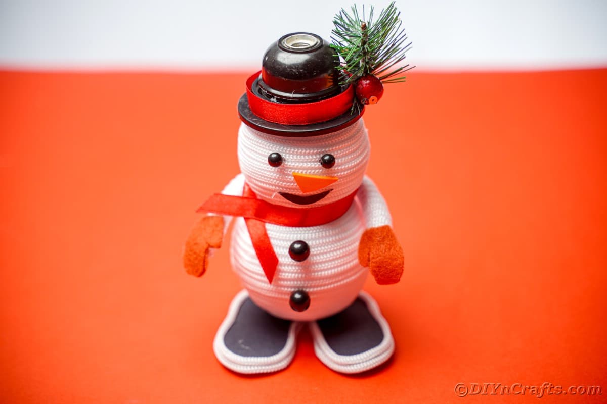 snežak iz vrvi, ki sedi na rdeči mizi