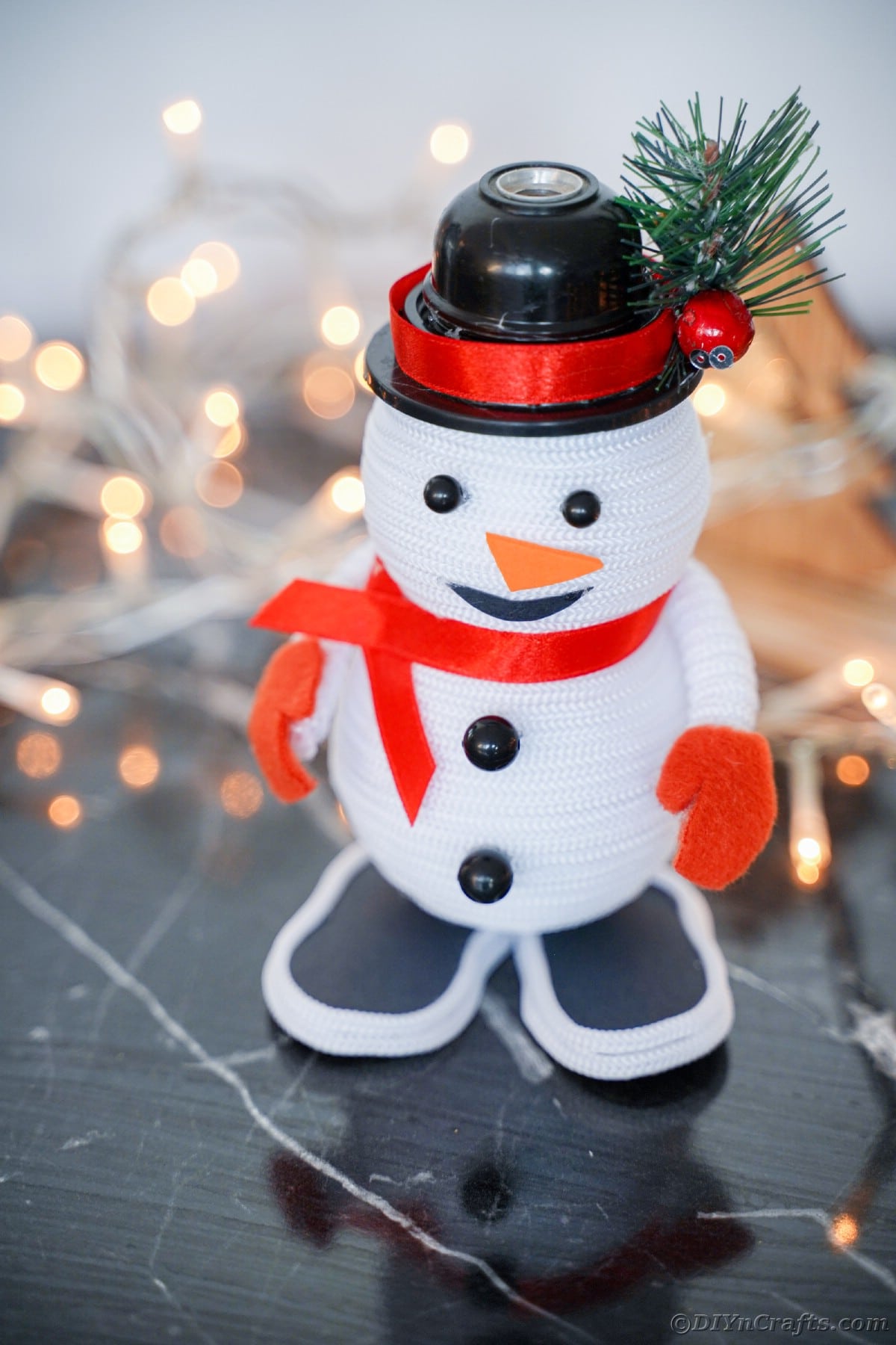 snowman decor on black table by twinkle lights