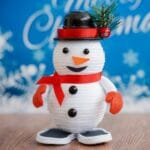snowman decoration in front of blue merry christmas sign