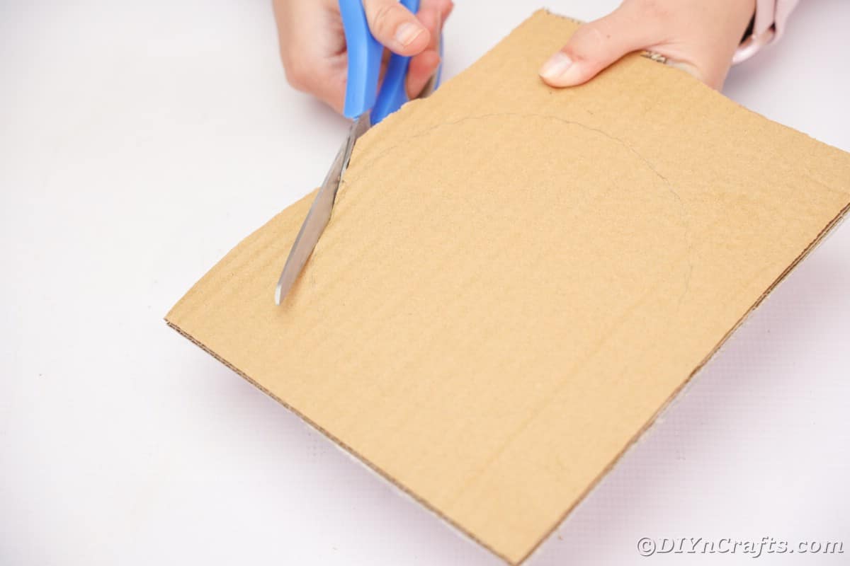 blue scissors cutting cardboard