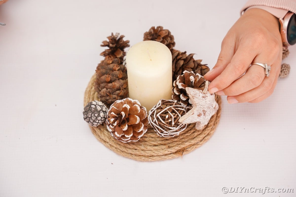 gluing star onto the side of pinecone centerpiece