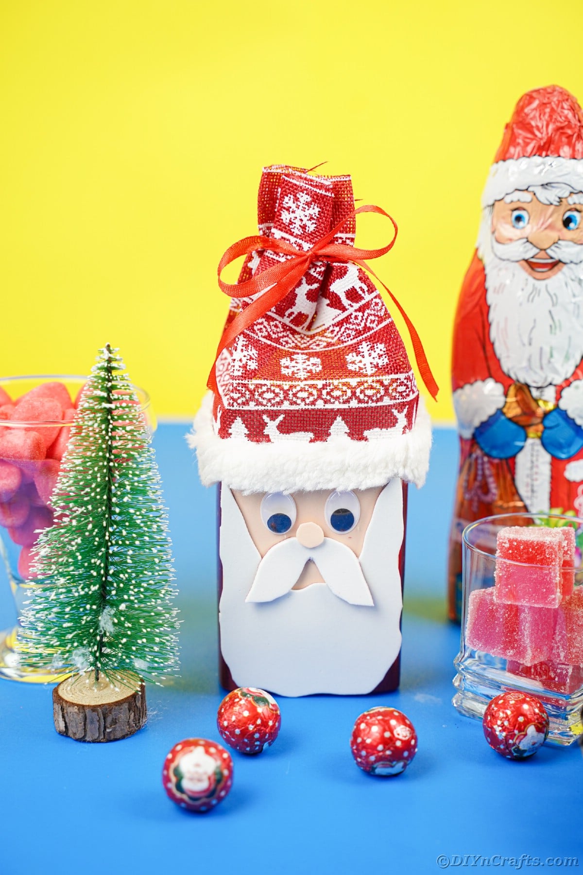 blue and yellow table and backgruond with a variety of santa claus figures and pinecones