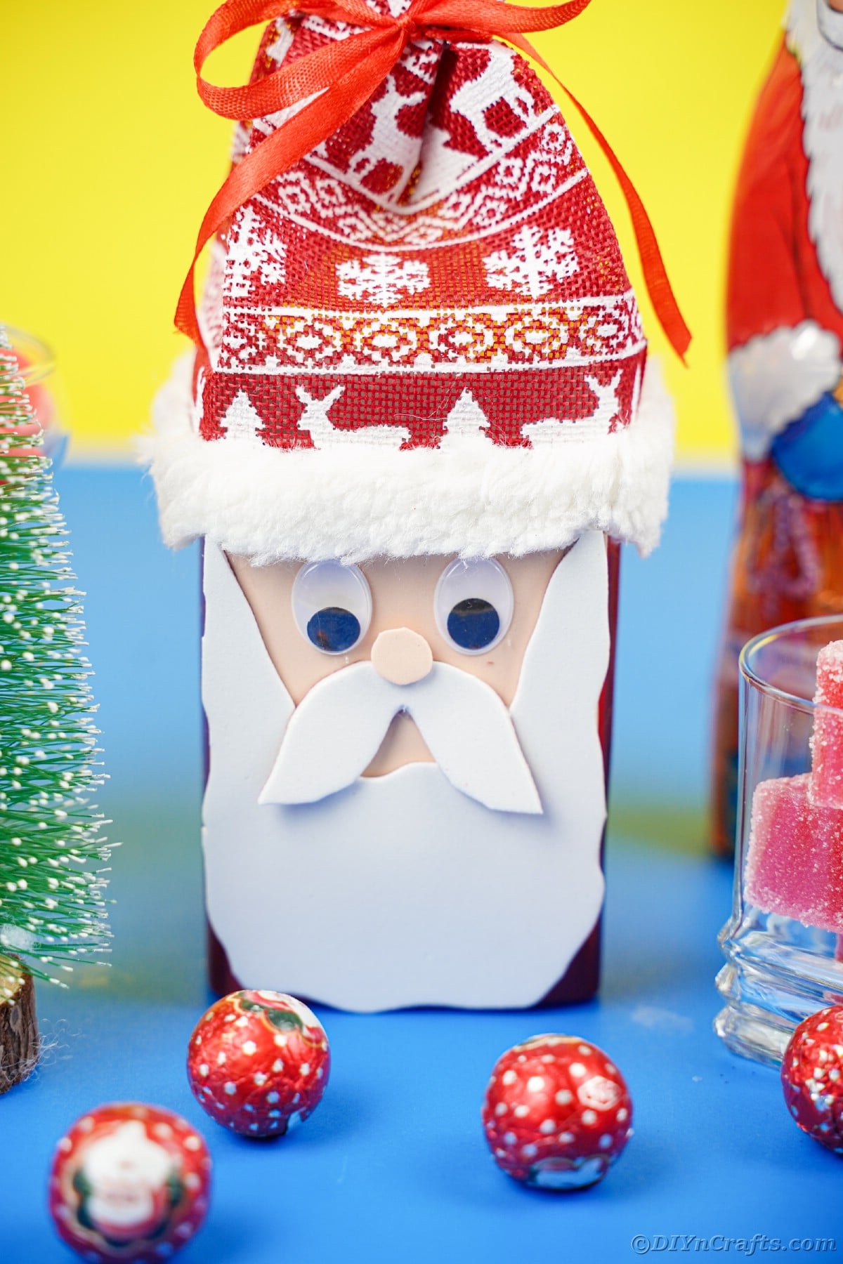 Božiček škatla s sladkarijami s krogličnimi bonboni spredaj sedi na modri mizi