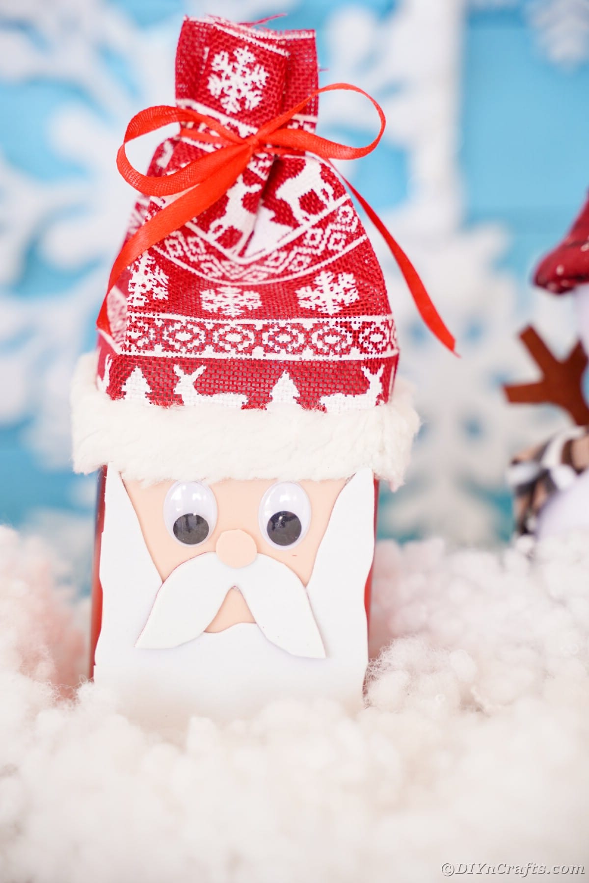Foam Santa face on box with Nordic hat sitting on fake snow