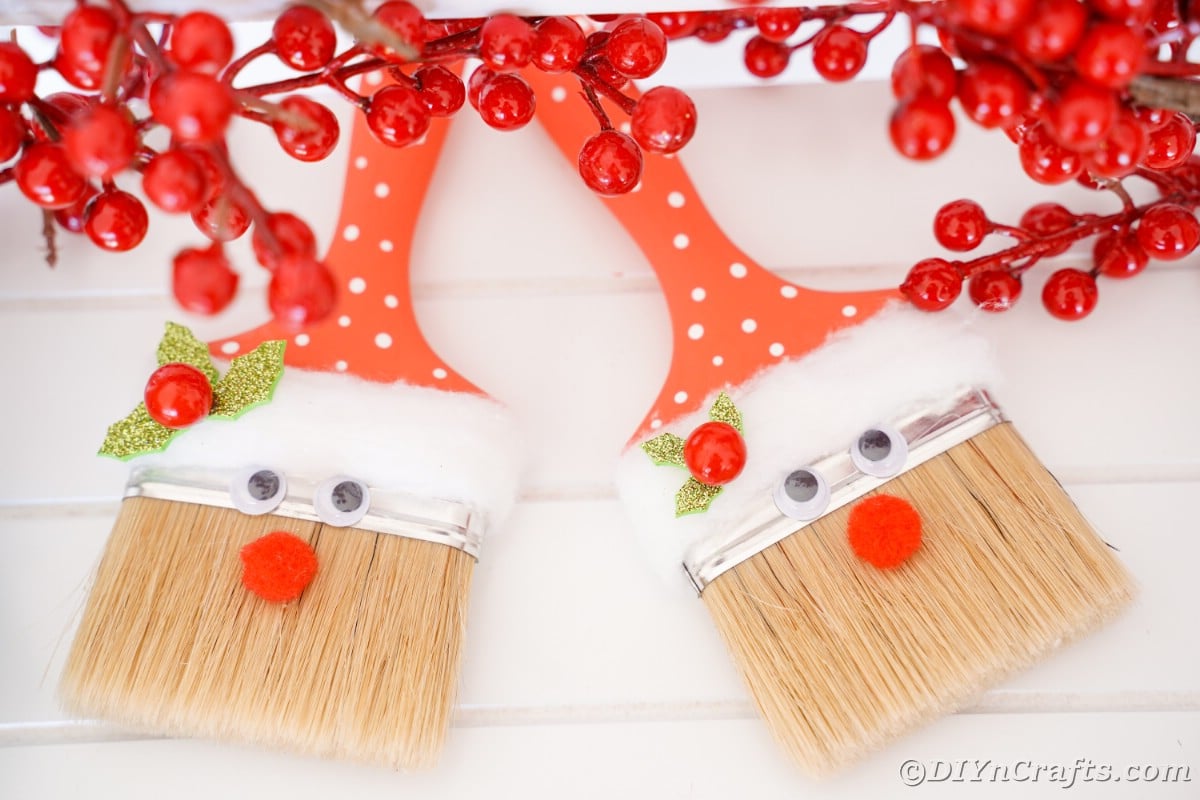 two paintbrushes painted red with santa faces