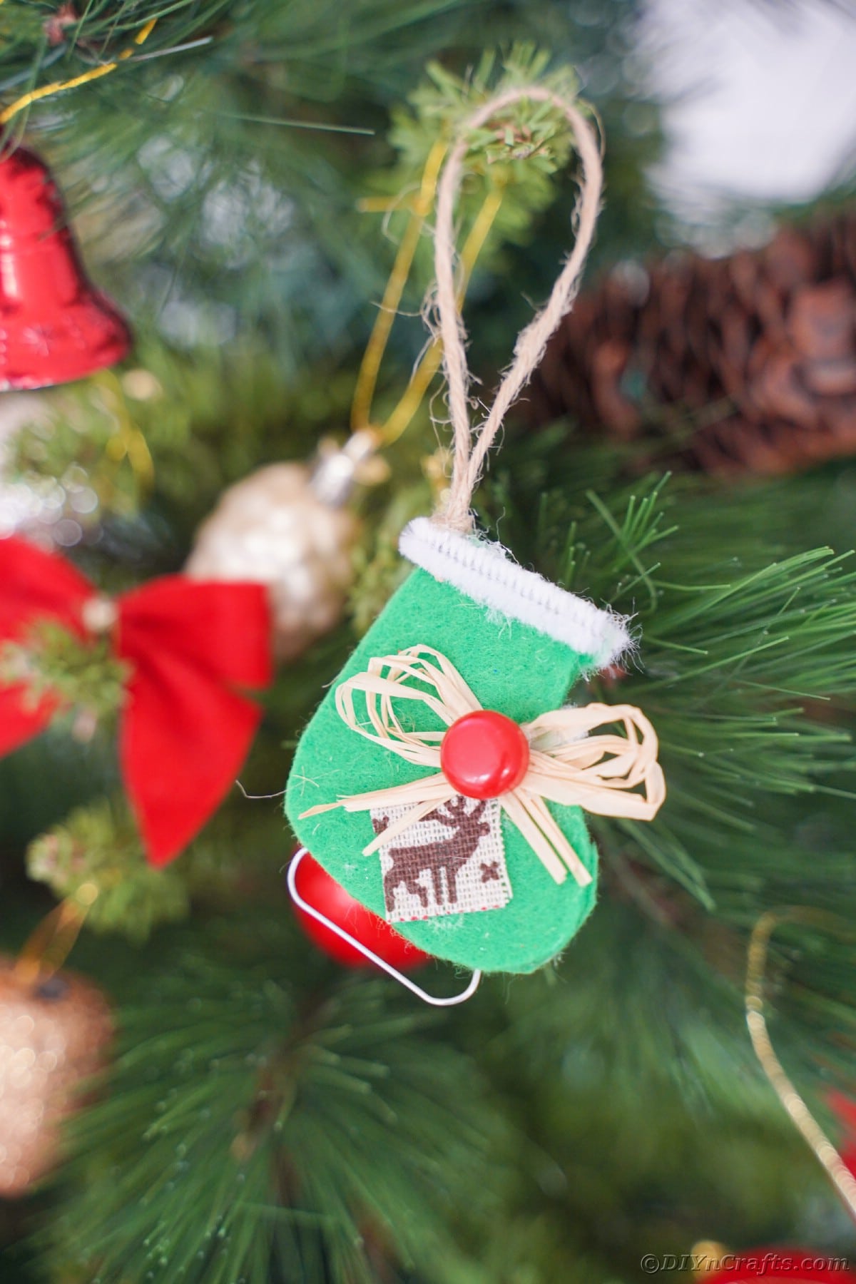 zeleni okras za drsalke iz klobučevine, ki visi na božičnem drevesu