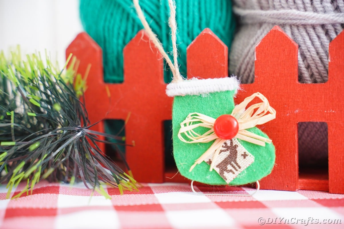 mini red fence with green ice skate ornament hanging off fence