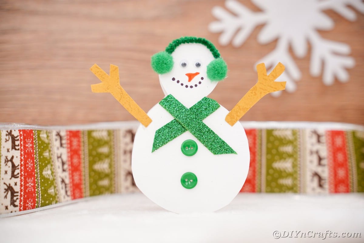 paper snowman in front of holiday theme paper