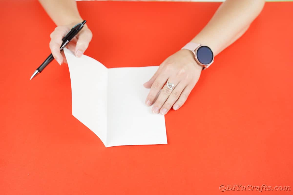 hand folding white paper in half
