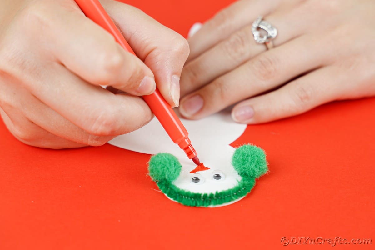 hand drawing nose onto paper snowman