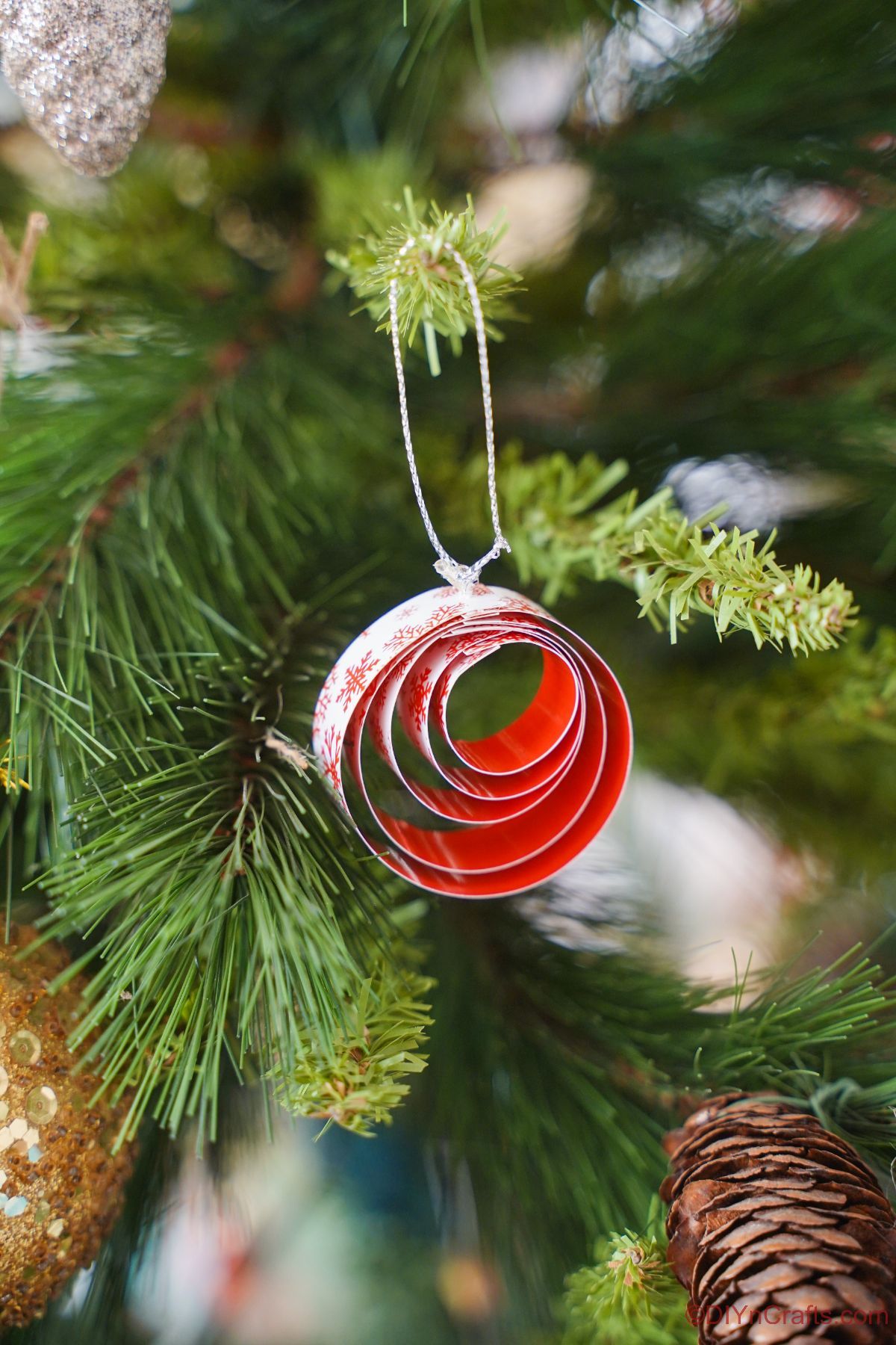 קישוט נייר אדום ולבן תלוי על עץ חג המולד