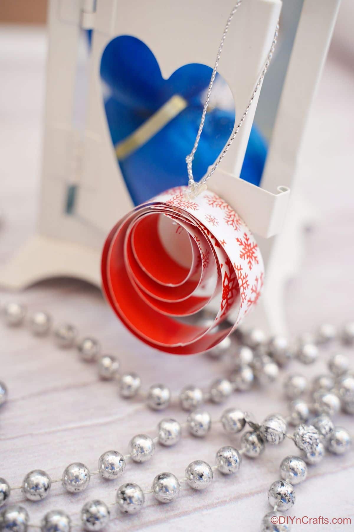 rdeče-bel okrogel papirnati okras na beli mizi z modrim ornamentom