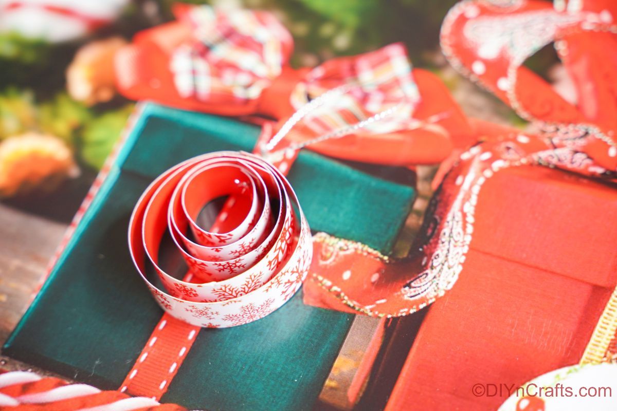 okrogel zvit papirnati okras, ki sedi na vrhu prazničnega papirja za božično darilo
