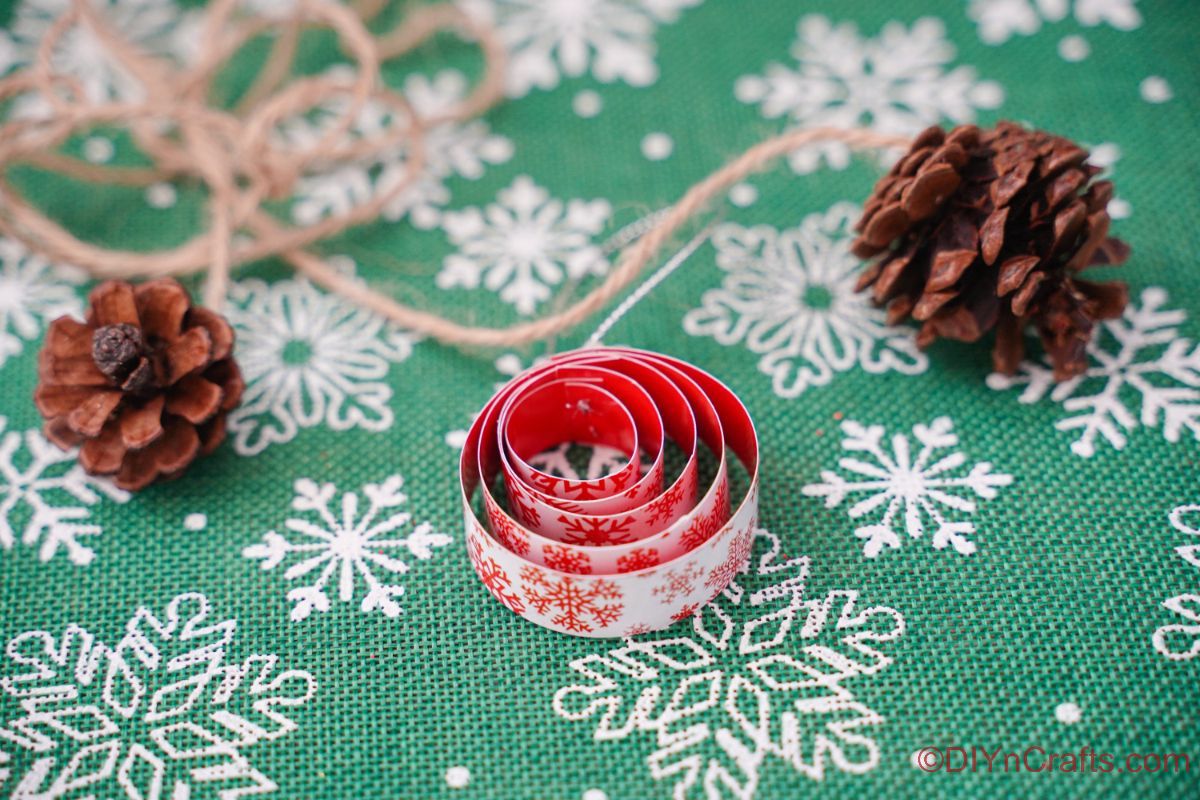 round rolled paper ornament on snowflake patterned green paper