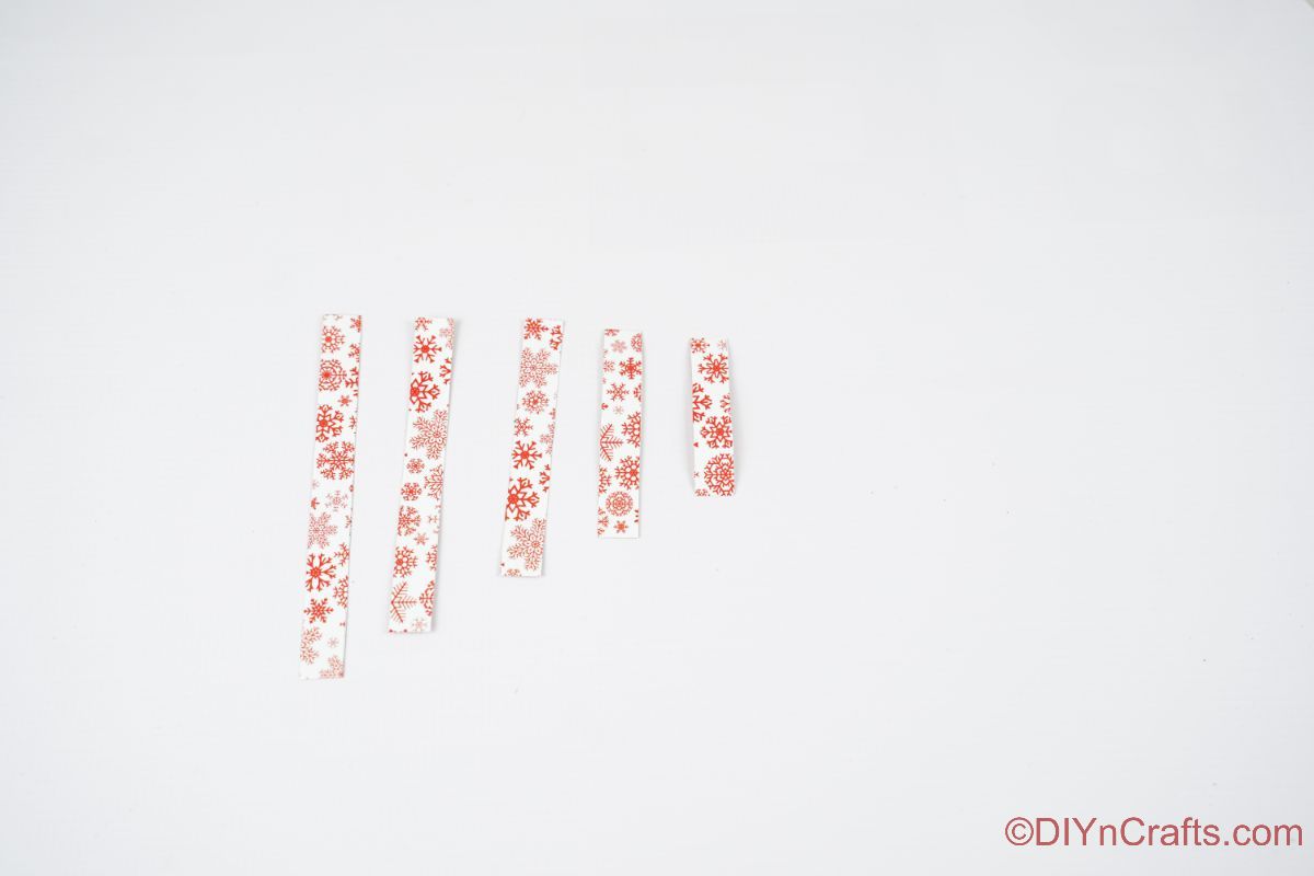 5 רצועות נייר בגדלים שונים על שולחן לבן