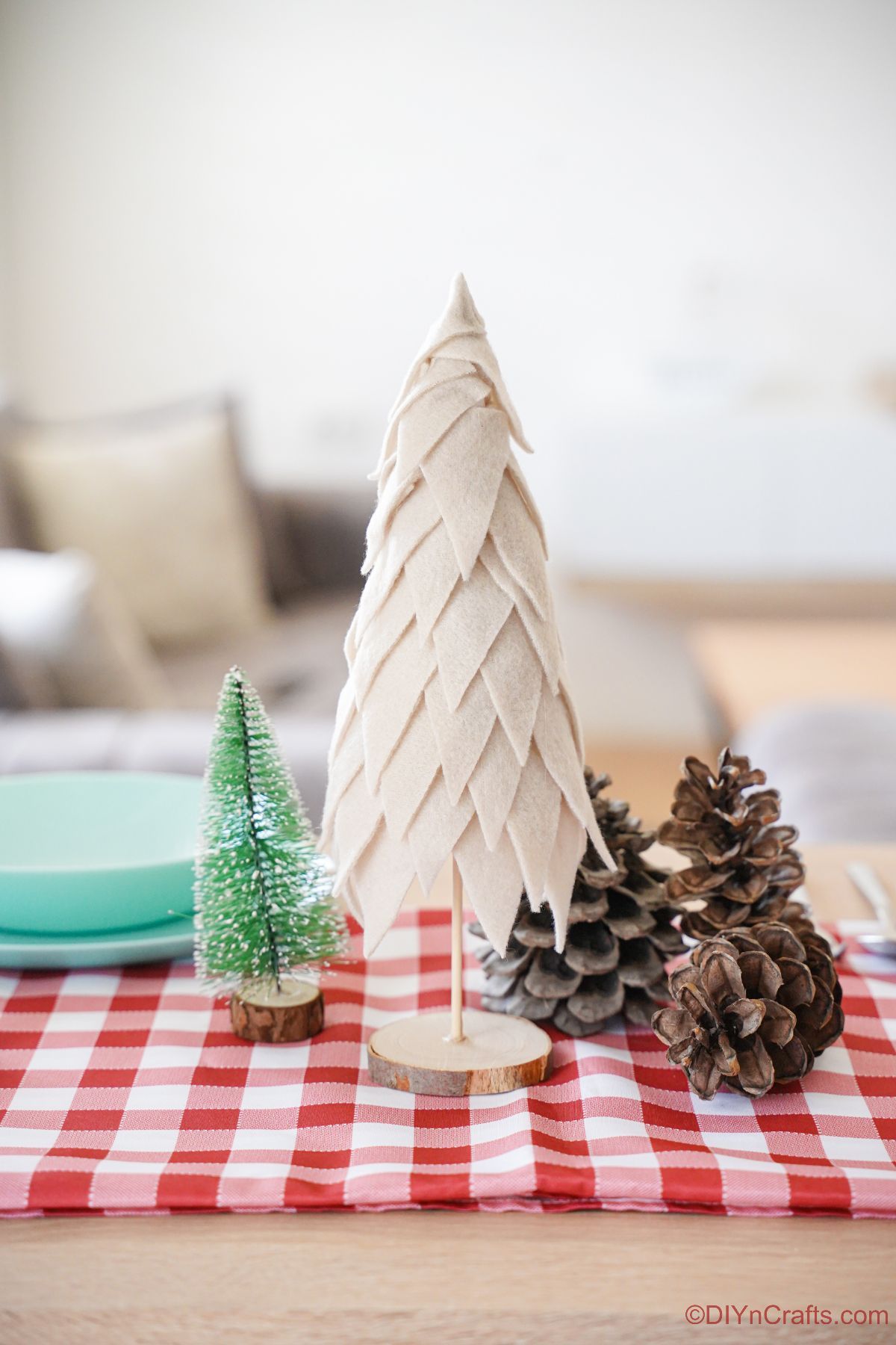 red and white checked tablecloth with mini tree on top next to light teal plates