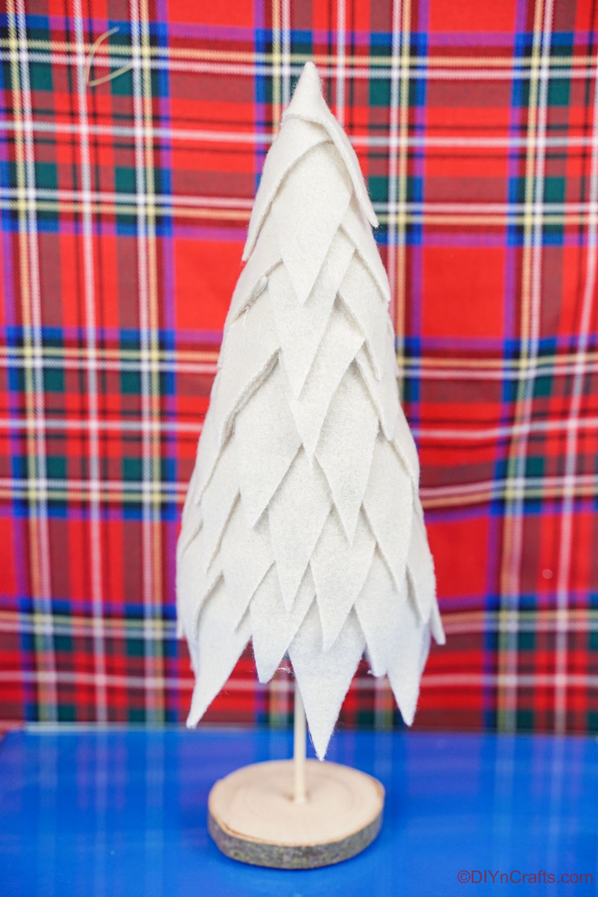 cream fabric tree on blue table by plaid background