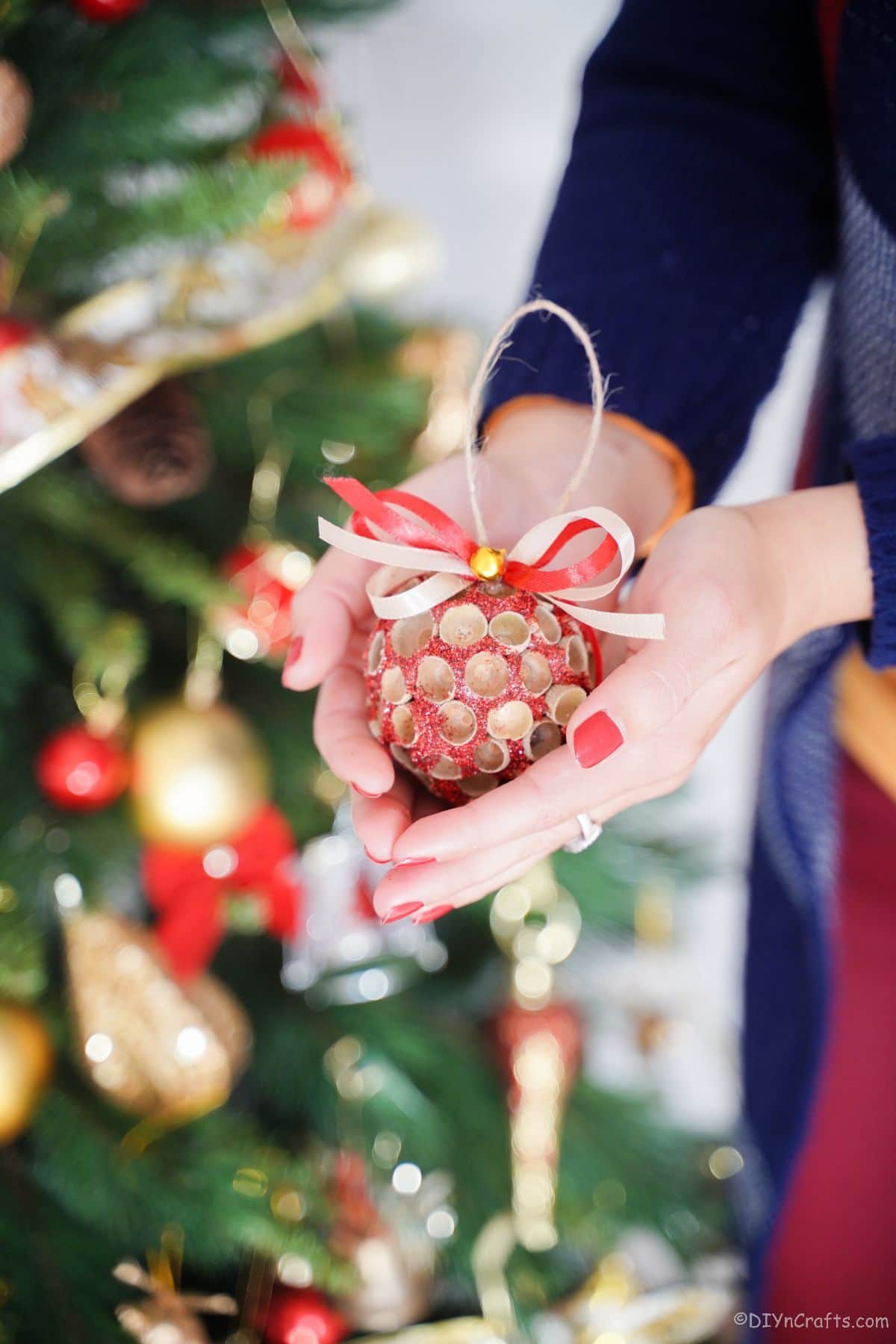 woman holding glitter ornament in hands
