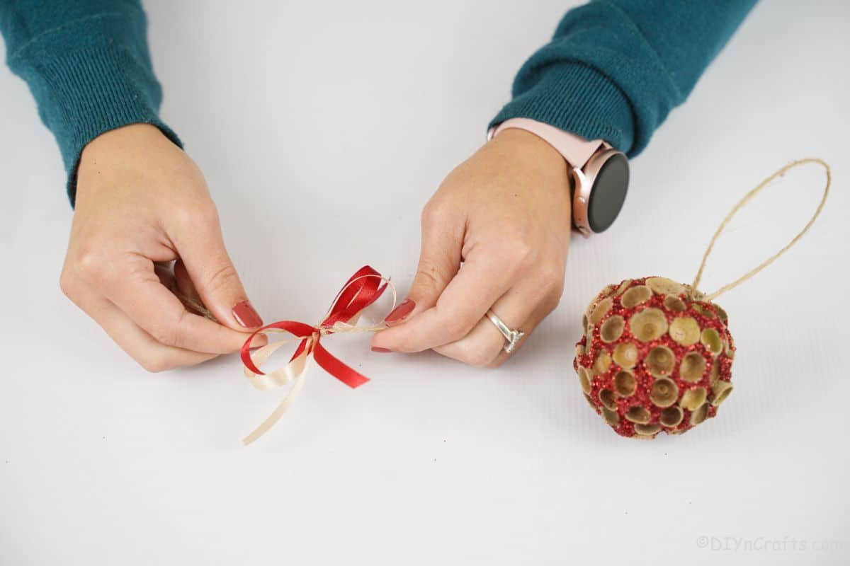 hands tying the red bow