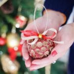 Glittery acorn cap ornament being held in womans hands