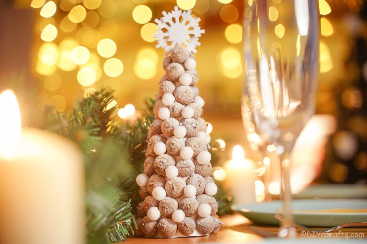 acorn cap tree on table with twinkle lights and glasses