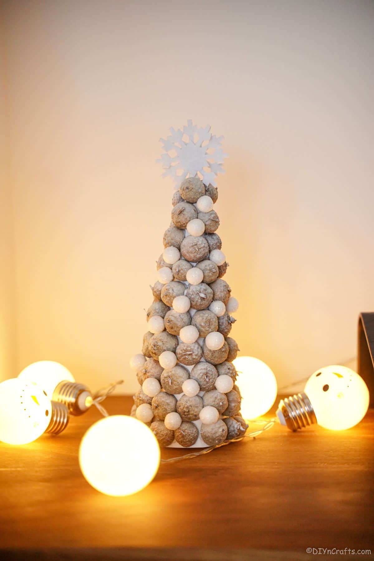 acorn cap tree on table with holiday lights