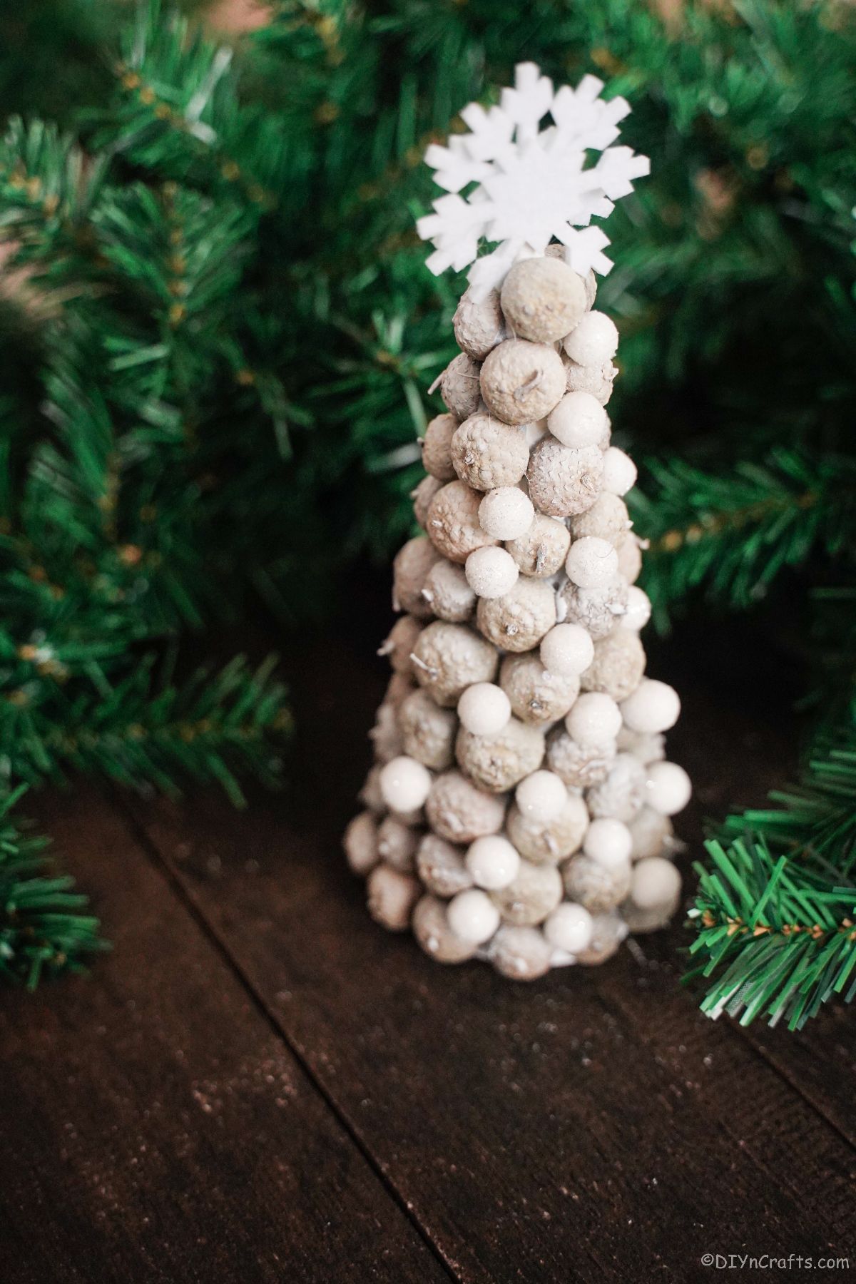 white mini tree on wood table by greenery