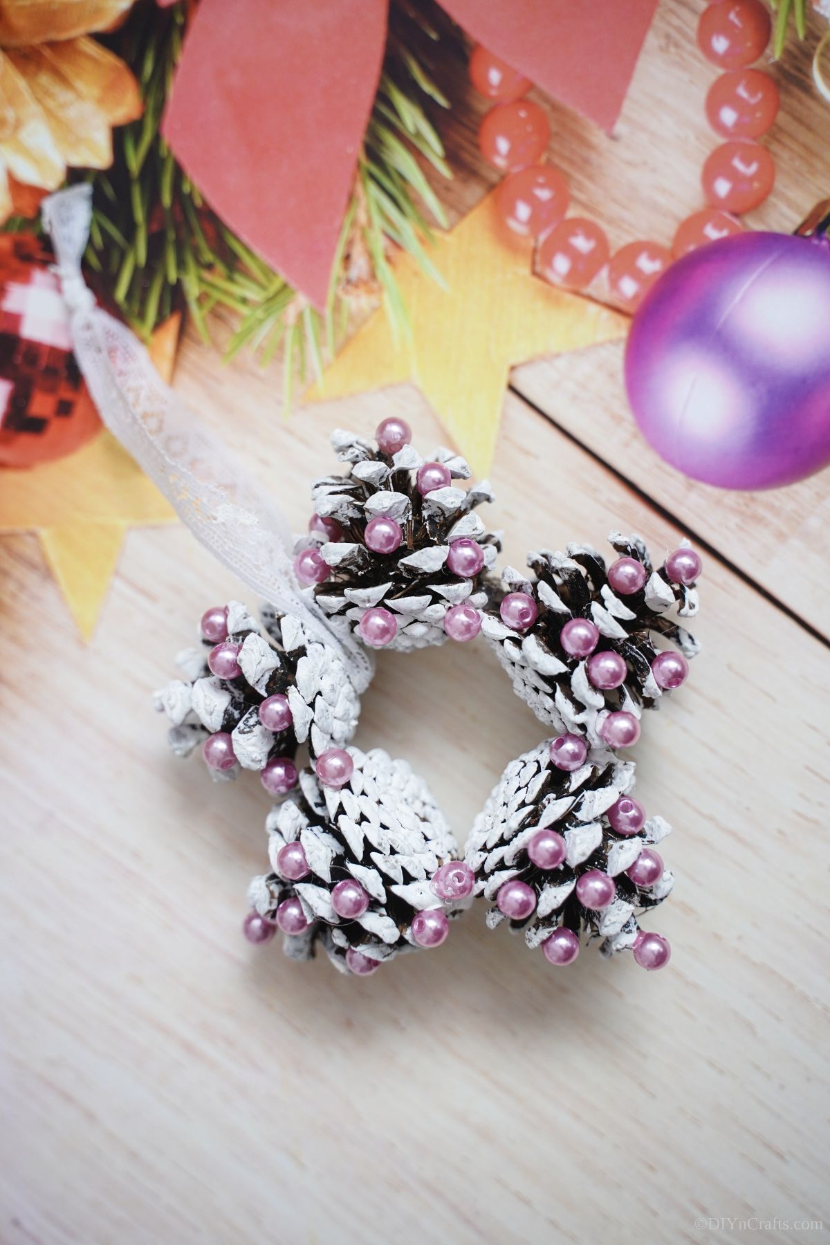 pinecone star ornament on cream holiday paper