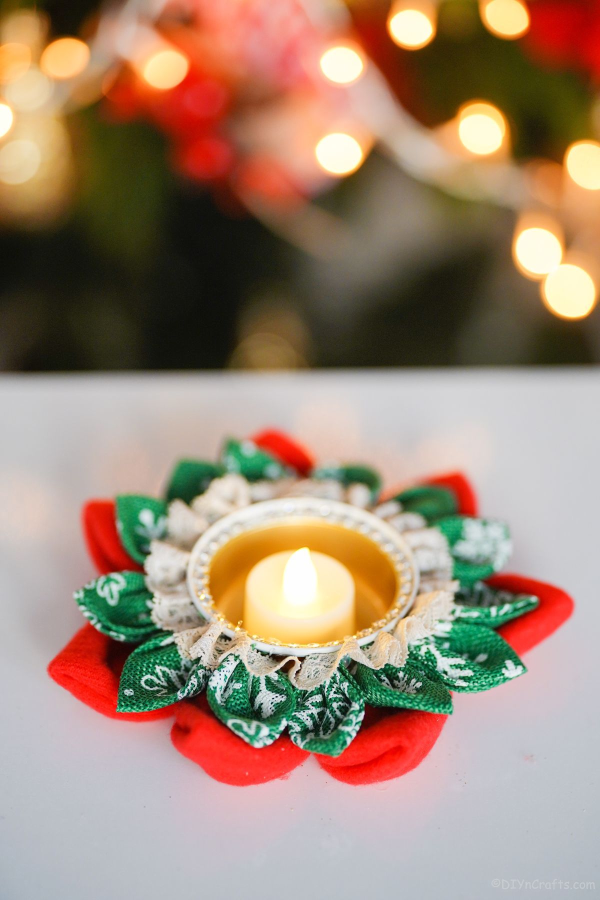 christmas candle holder on table by Christmas tree