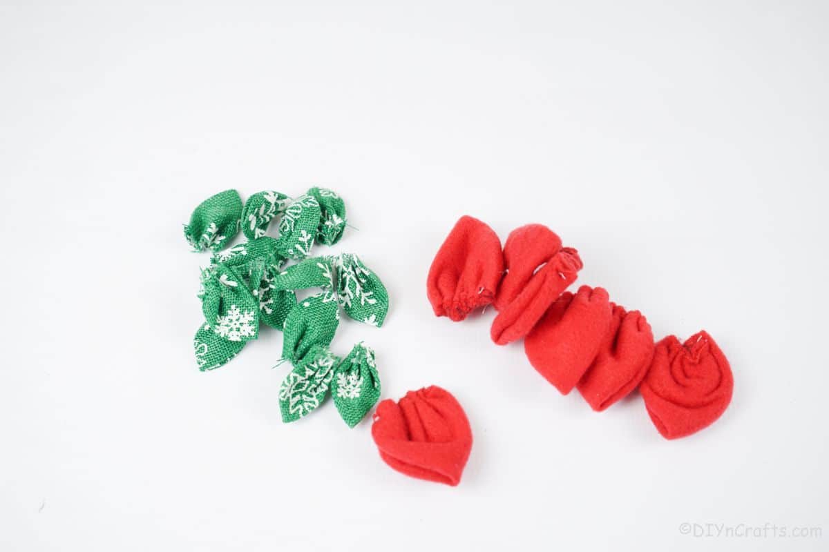 fabric flower petals in green and red on white table