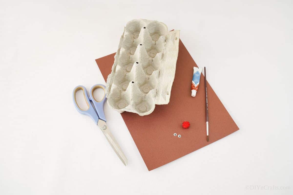 scissors on table by brown paper and egg carton