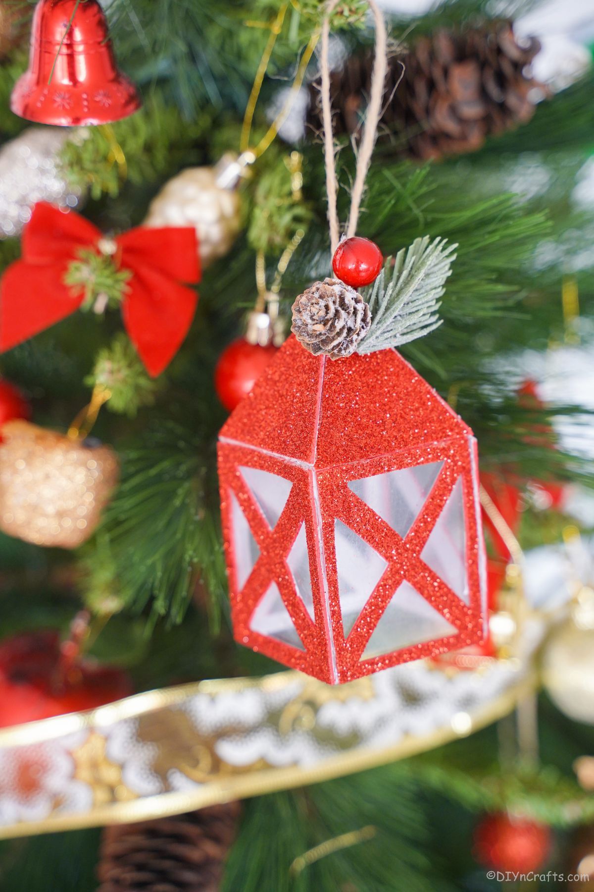 miniaturna rdeča papirnata lučka, ki visi na božičnem drevesu