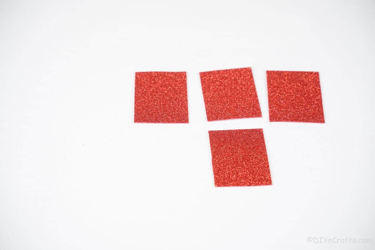 four rectangles of red glitter paper