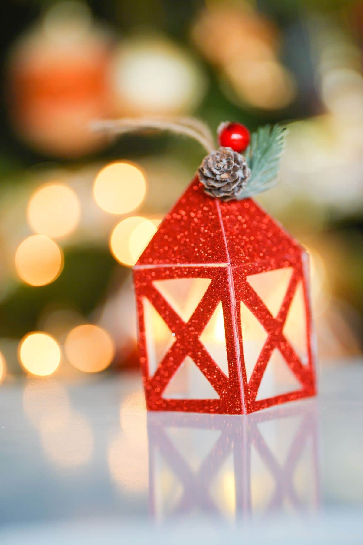 red glitter paper lantern on table by Christmas tree