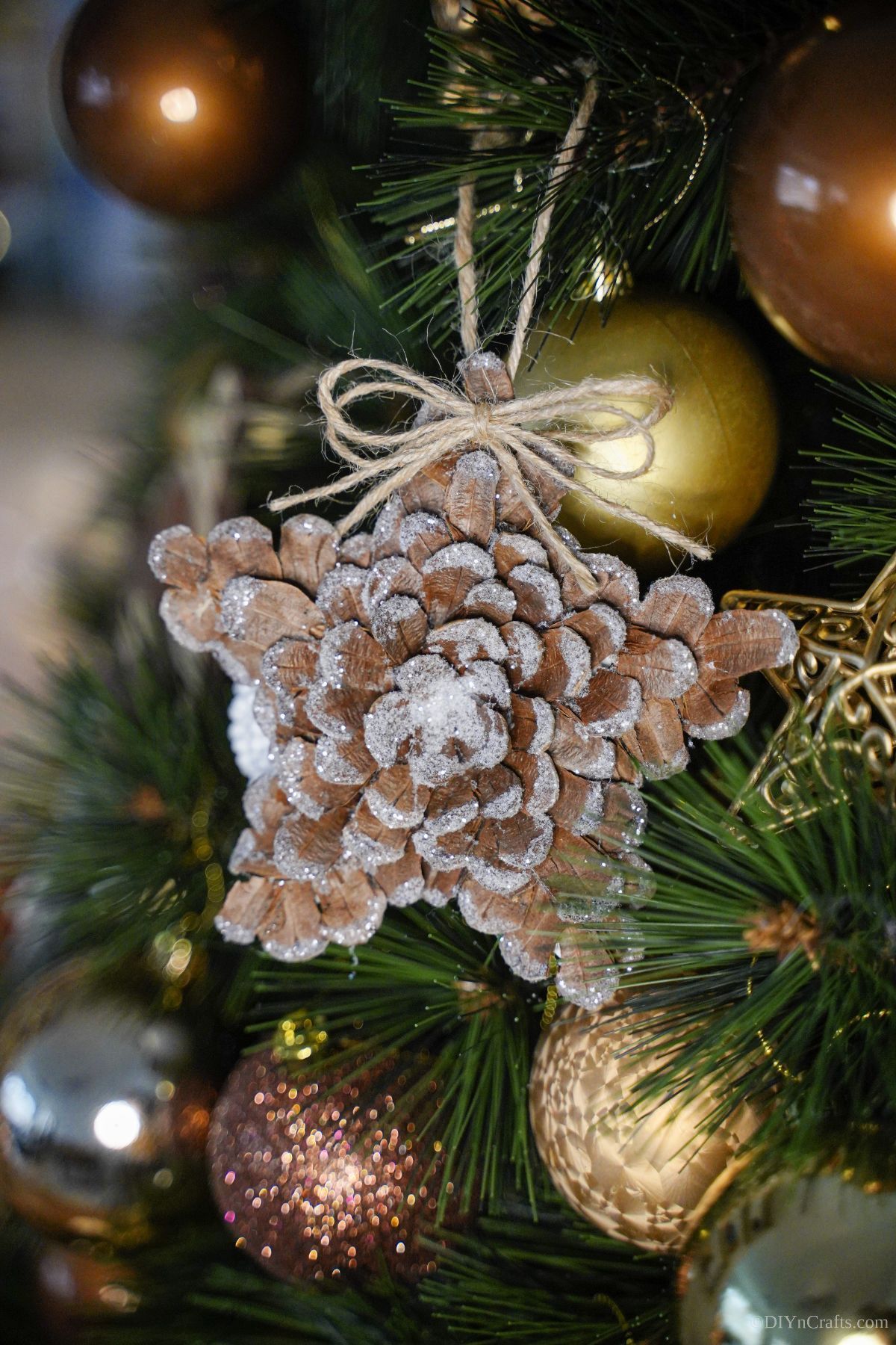 pinecone star ornament on holiday tree with gold ornaments