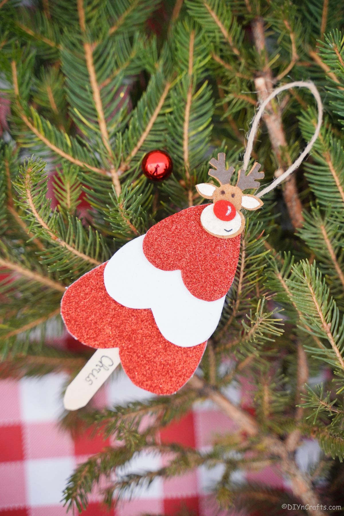 rdeče-bel ornament v obliki drevesa na božičnem zelenju