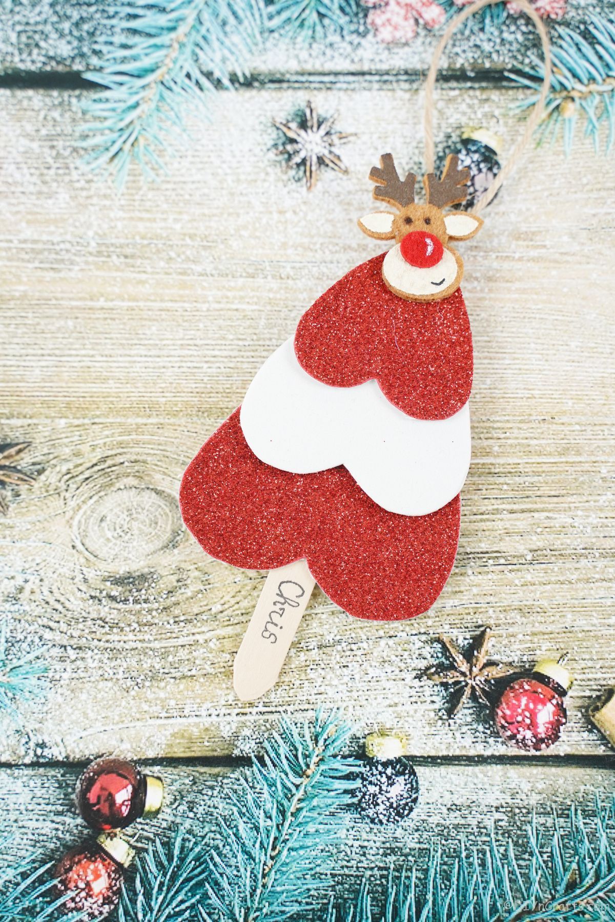 paper candy cane striped mini tree ornament placed on holiday themed paper