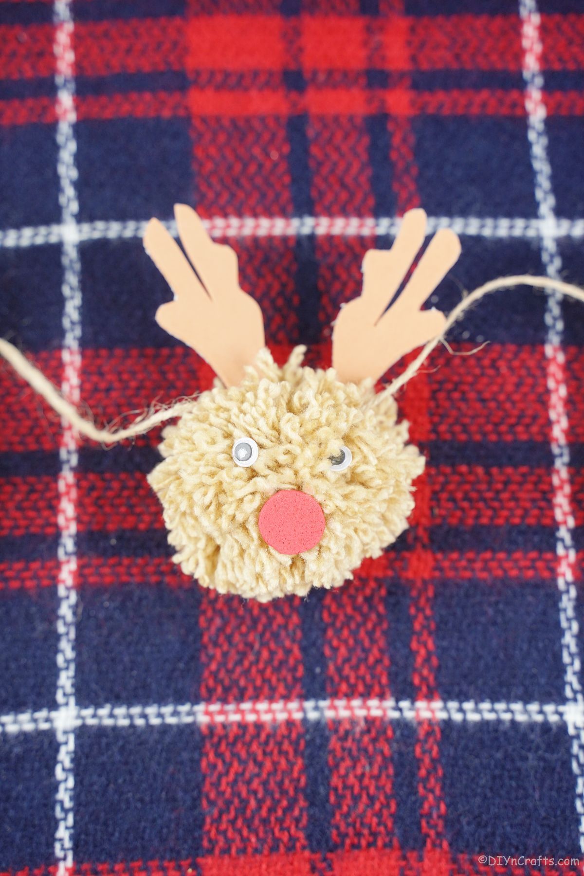 light brown yarn reindeer on plaid fabric