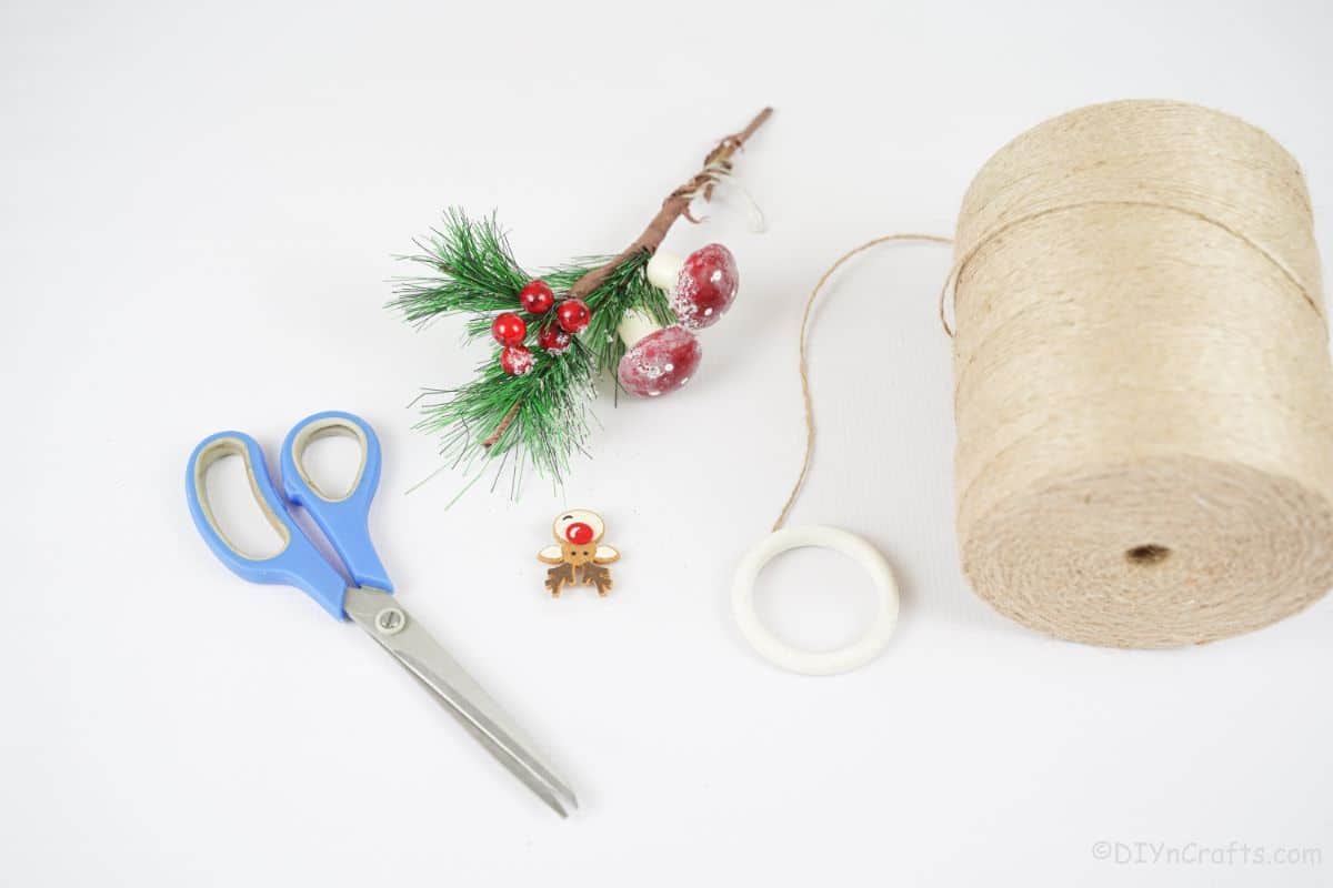 twine on white table by styrofoam ring and holiday picks