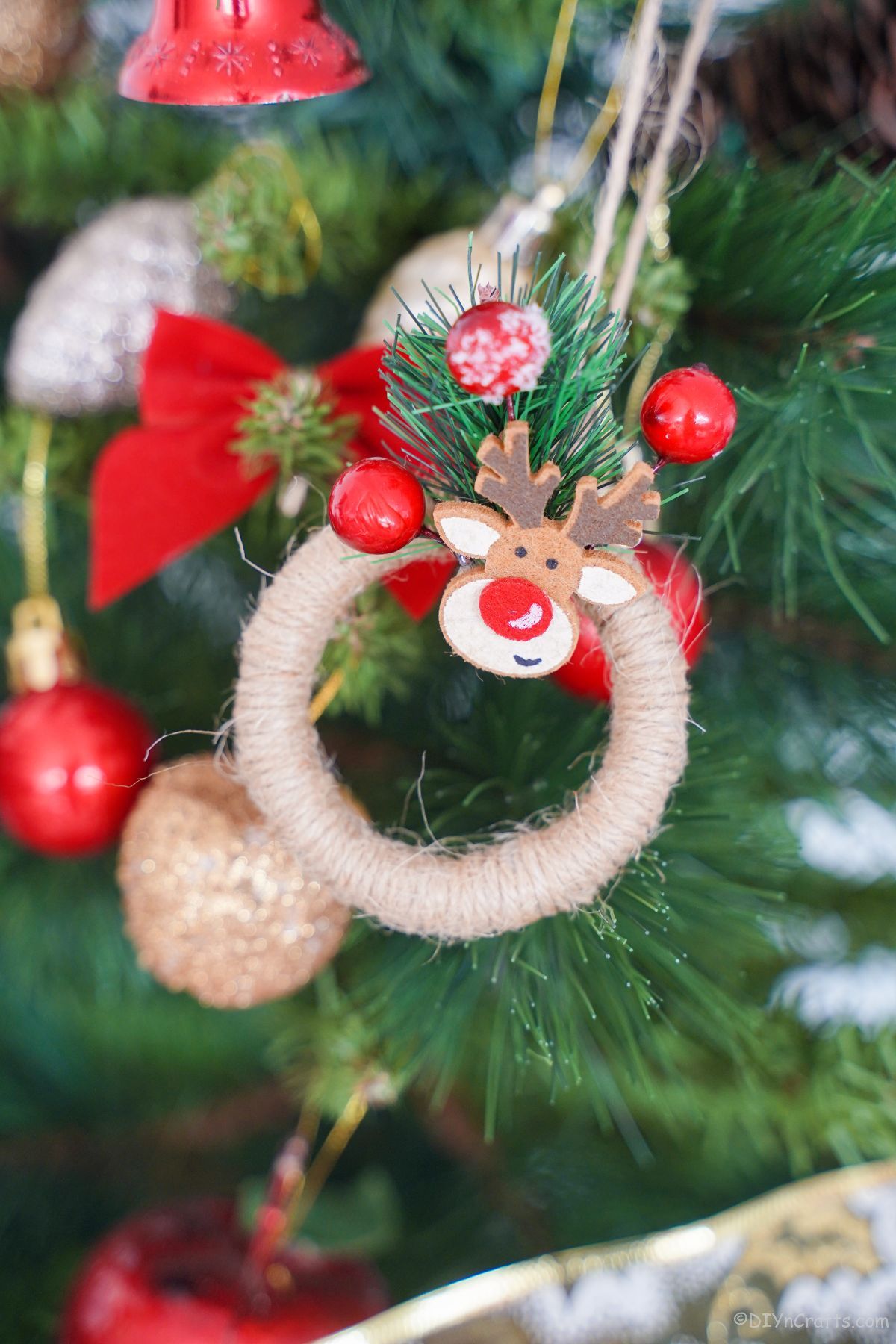 twine wrapped mini wreath with rudolph on top hanging from tree