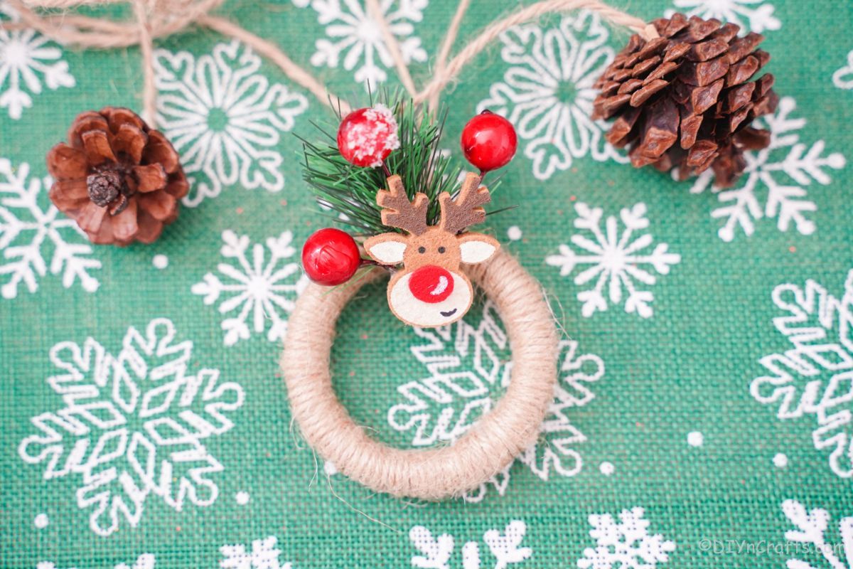 mini wreath ornament on green and white snowflake paper