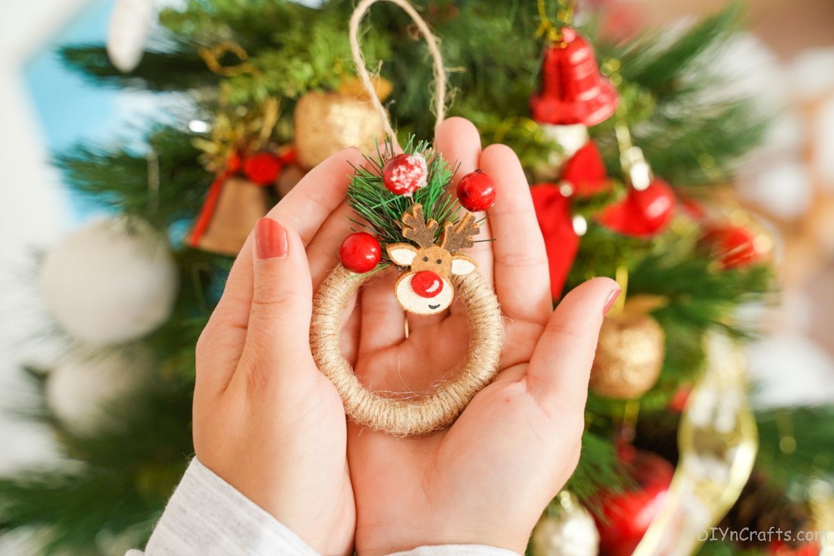 hands holding a miniature wreath ornament