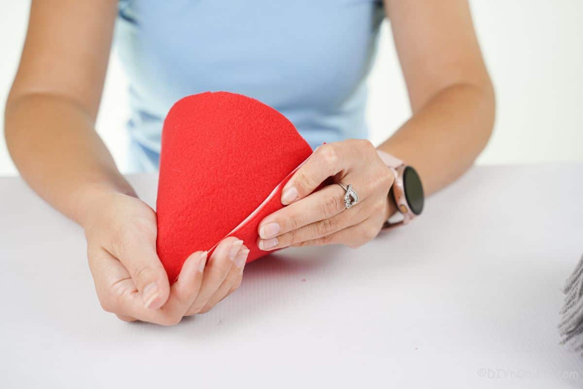 hands rolling red felt into cone hat