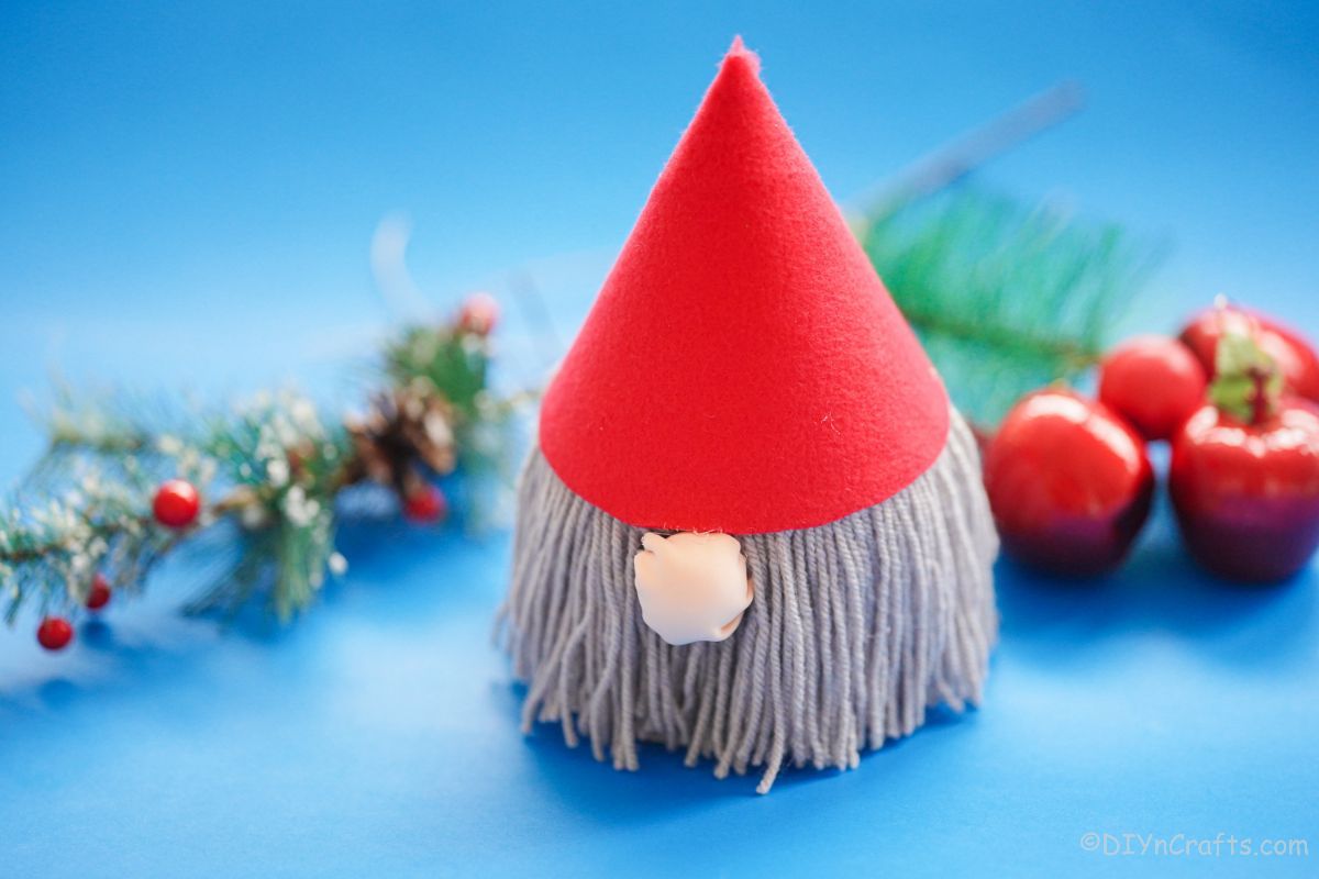 gnome with gray beard on blue table with christmas decorations