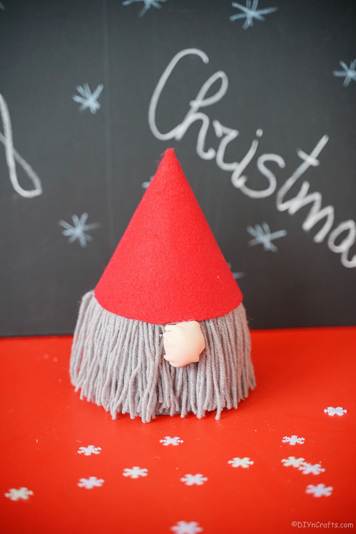 red hat gnome on red table with chalkboard background