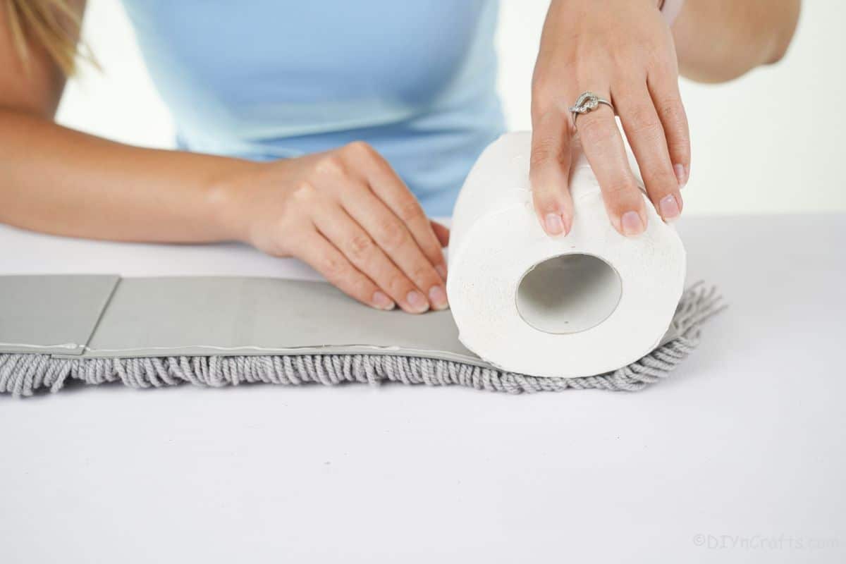 hand rolling yarn base around toilet paper roll