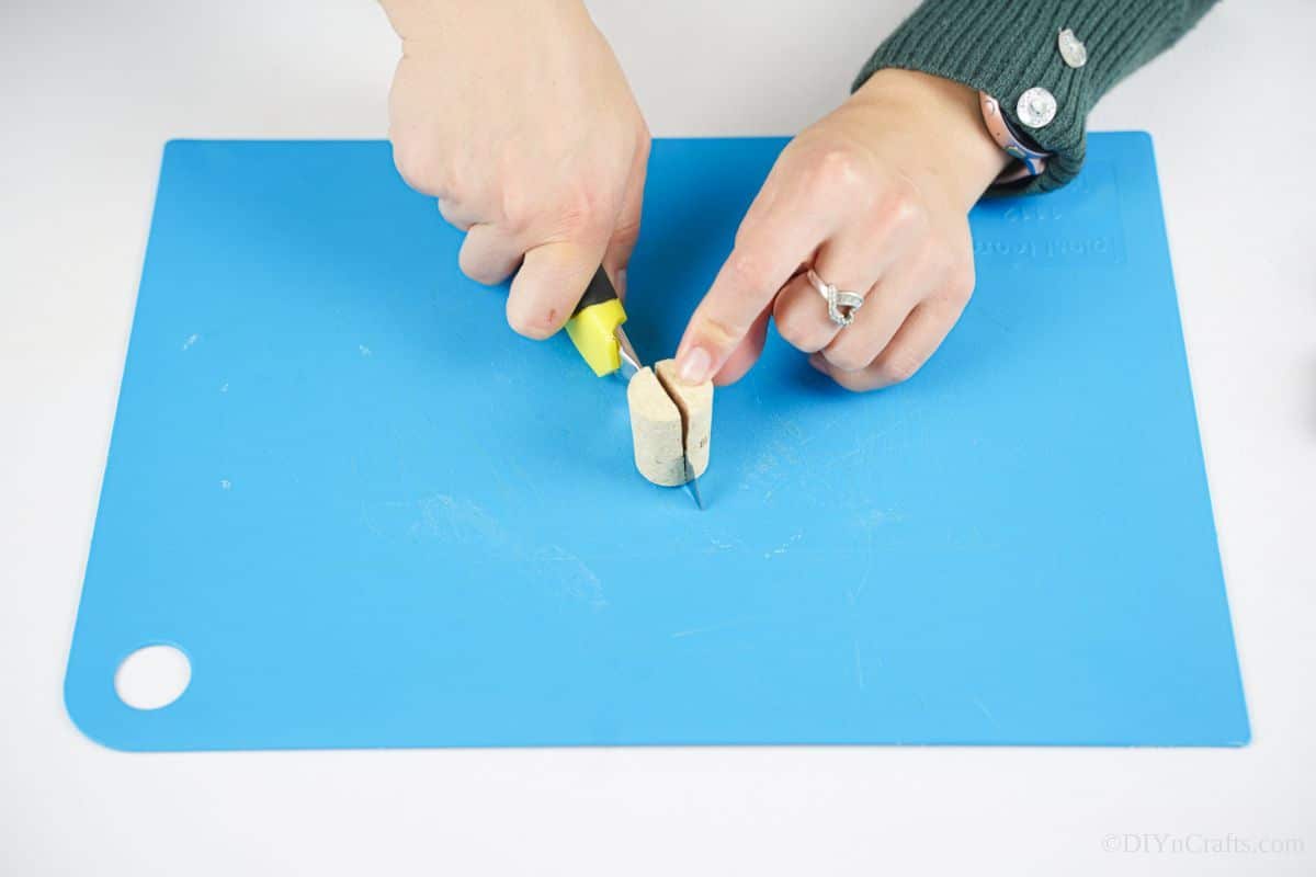 yellow craft knife being used to cut cork in half