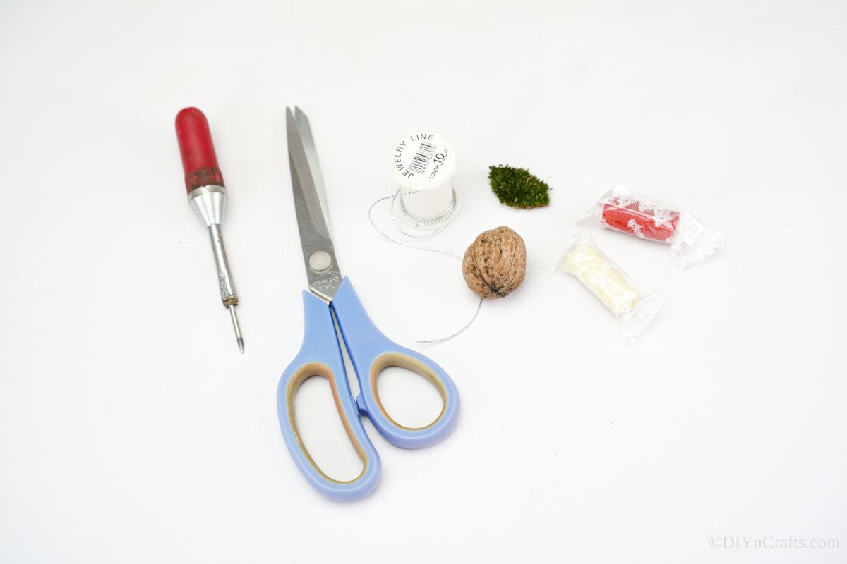 scissors walnut string and modeling clay on white table