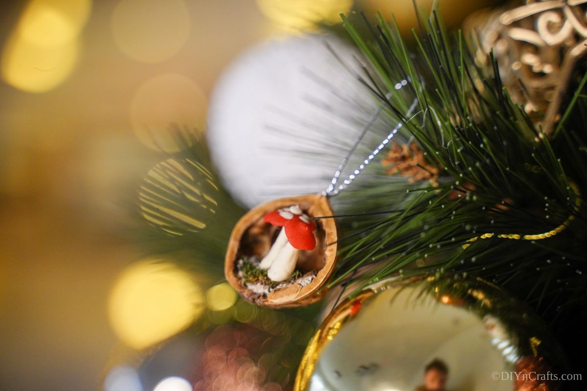 walnut shell ornament on tree by gold ornament