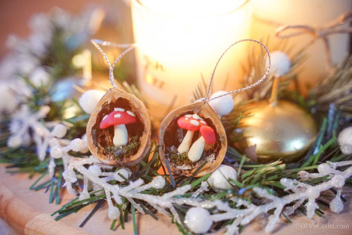 mushroom ornaments on table by greenery and candle